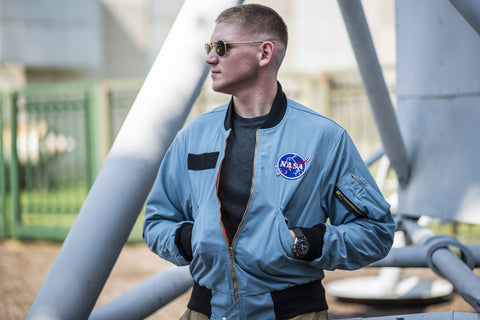 Man wearing blue Apollo-style NASA flight jacket and sunglasses in front of Apollo Lunar Module